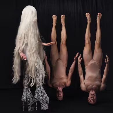 immagine due uomini capovolti e una persona capelli lunghi biondi