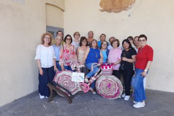 l'assessora Valentina Giro con le bibliotecarie e le signore del Gruppo Knit mostrano la bicicletta rivestita con lavori a maglia