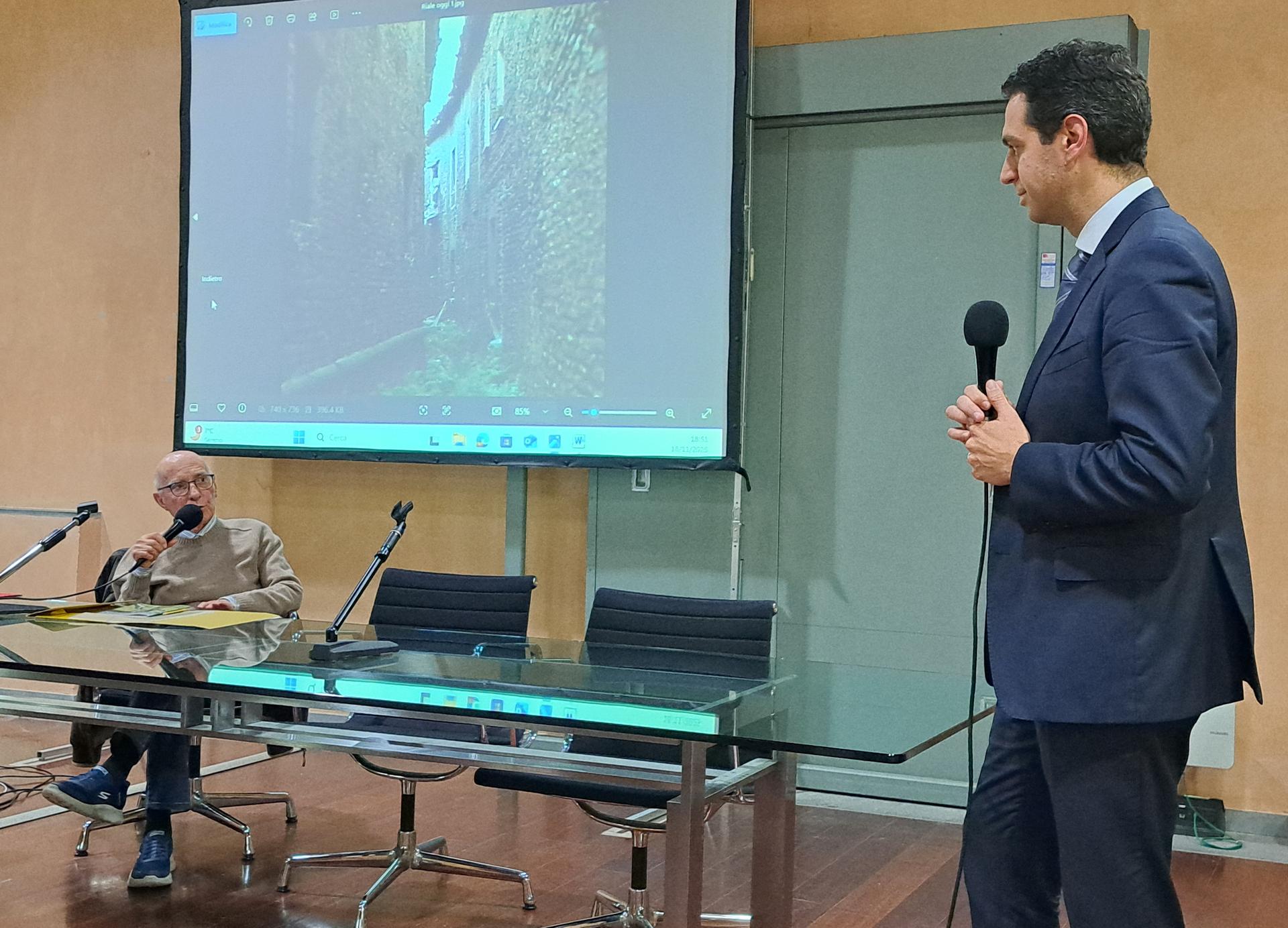 Mario Fumagalli e il Sindaco Orlandi, alle spalle l'immagine dell'anfratto dietro le vecchie carceri    

 