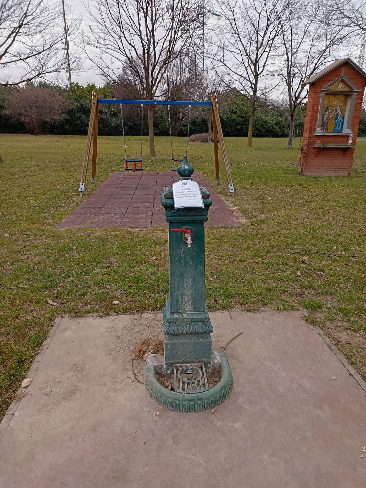 fontana in un parco giochi con indicazione di chiusura periodo invernale