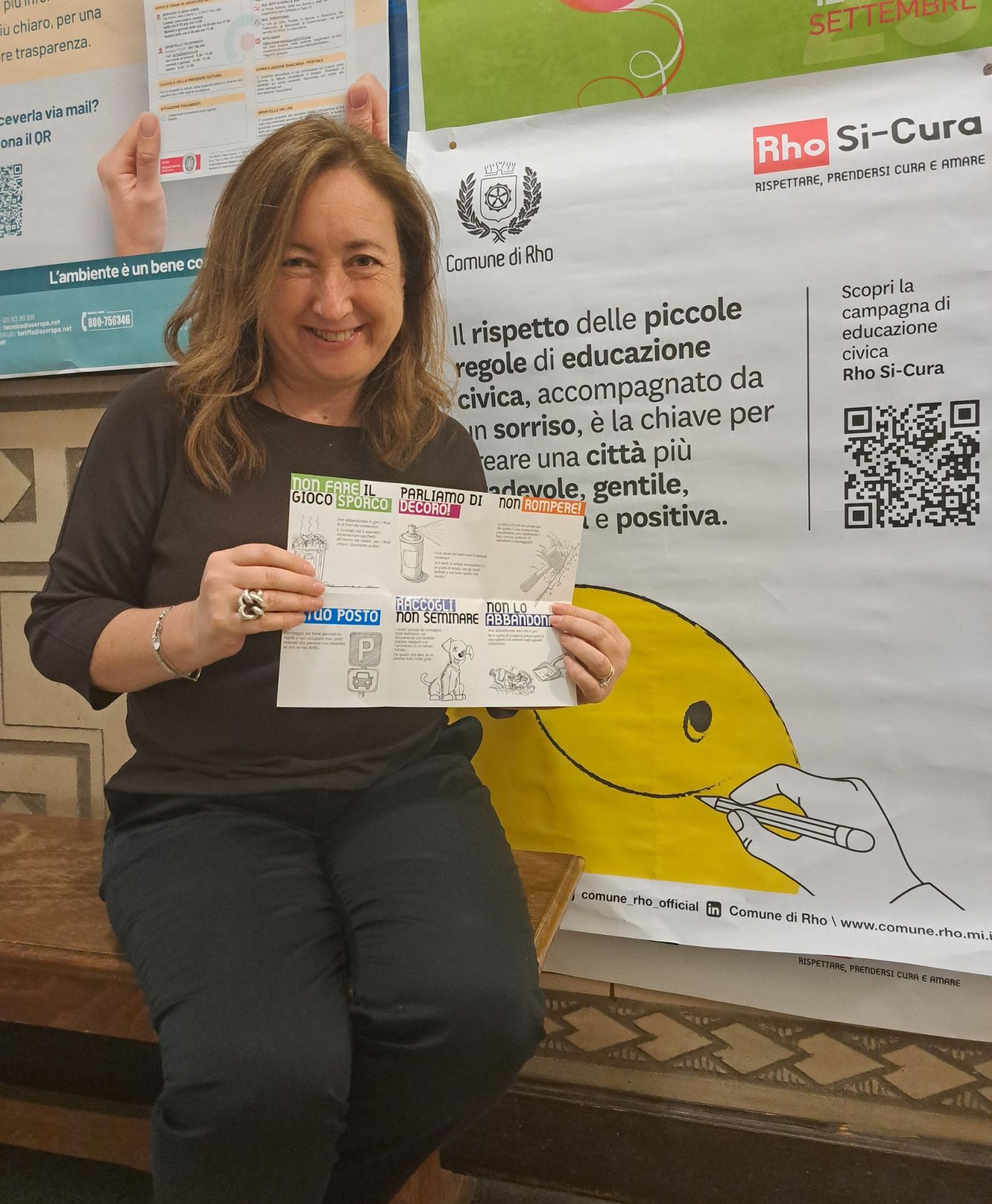 il Vicesindaco Maria Rita Vergani mostra il pieghevole che riassume le diverse regole, accanto al manifesto della campagna Rho Si-Cura