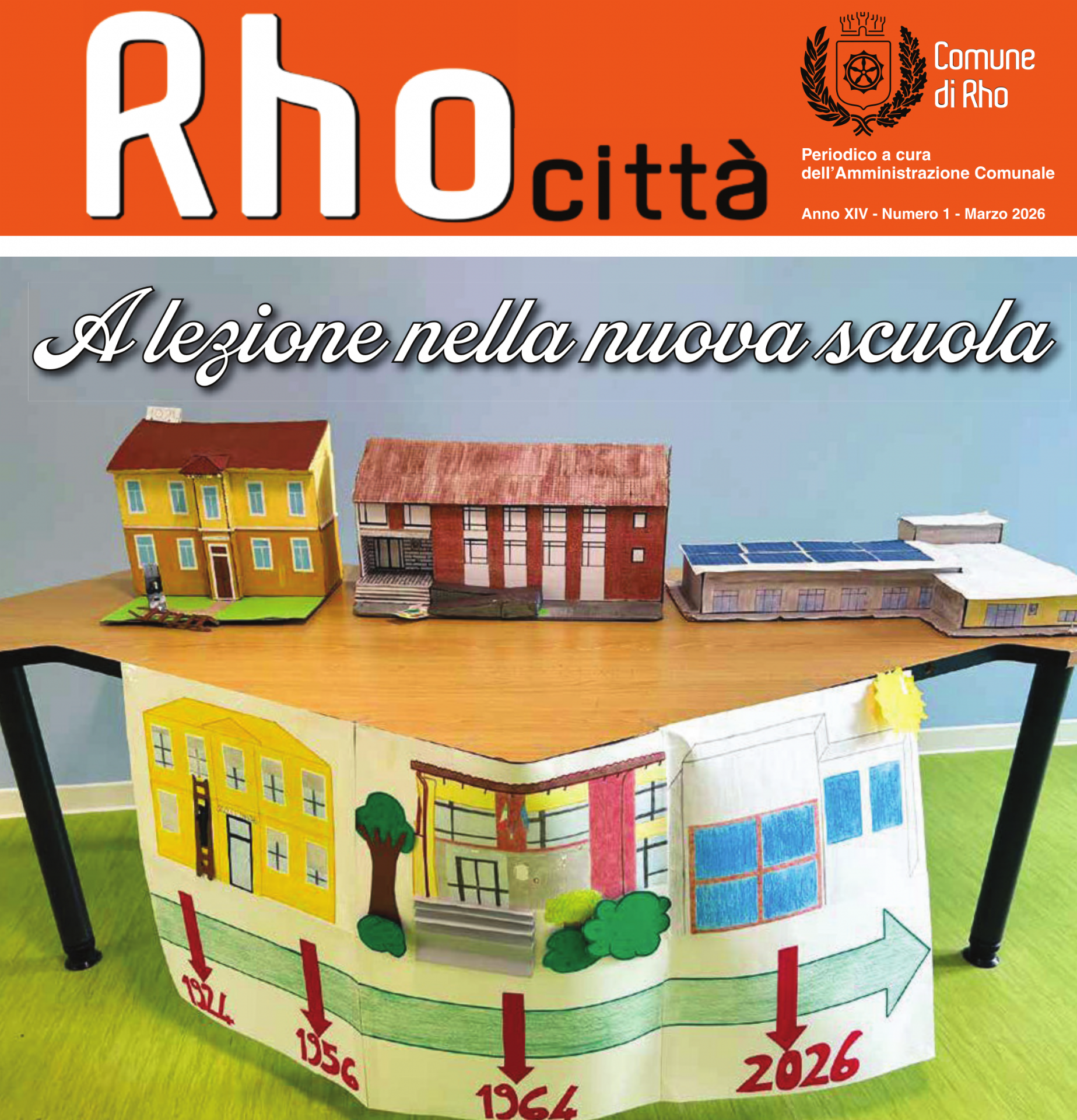 prima pagina di Rho città mese di marzo. A lezione nella nuova scuola. un tavolo con delle scuole in cartone colorare e un cartello con la trasformazione della scuola dal 1924 al 2026