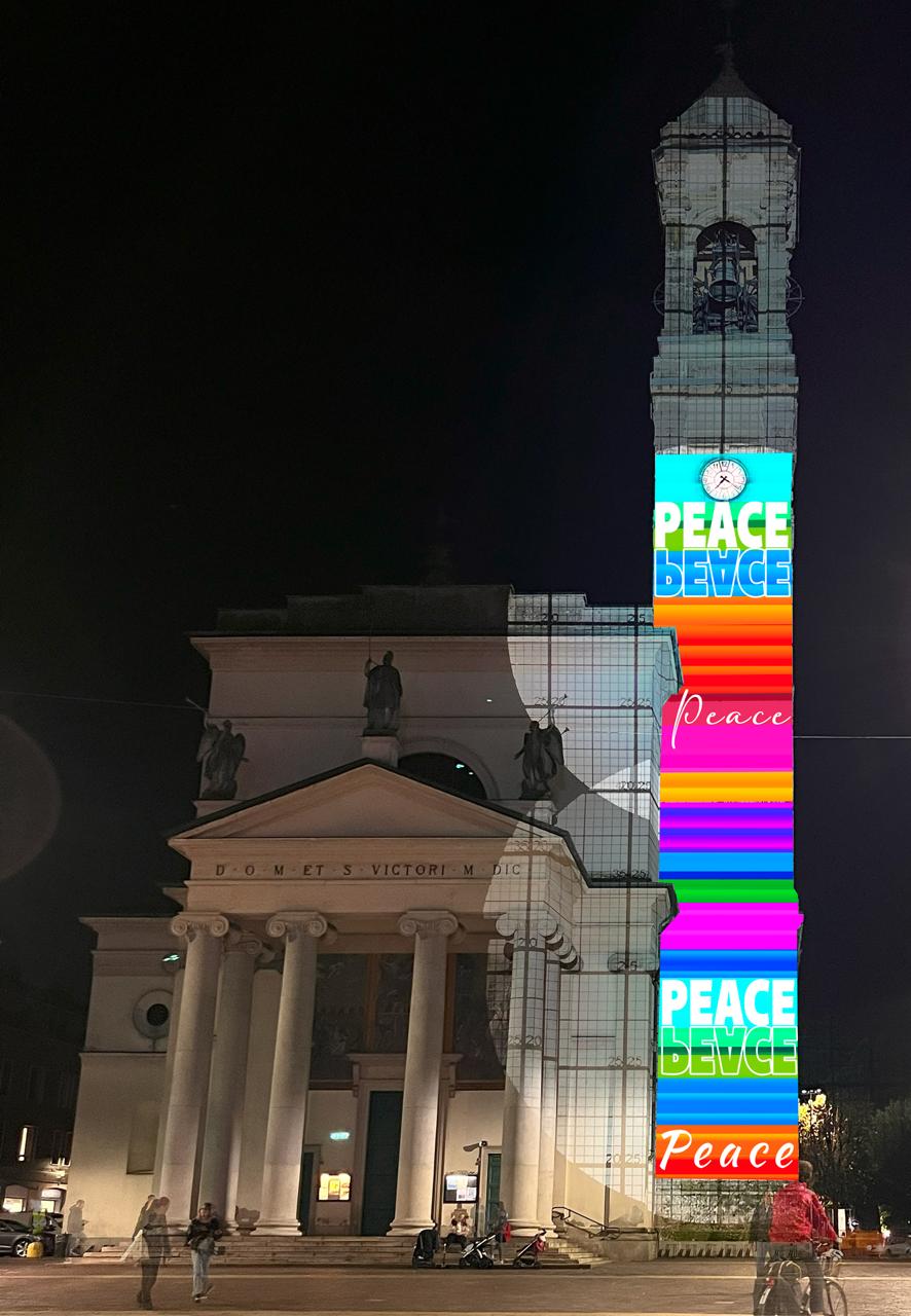 il campanile di San Vittore illuminato con simboli di pace